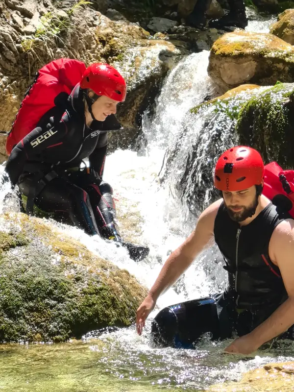 Pružena ruka gošći na kaskadi vodopada