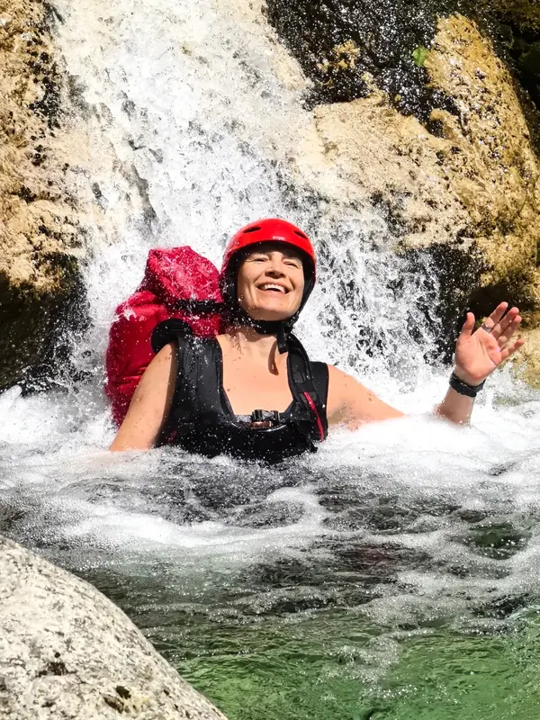 Nasmijana gošća u bazenu ispod vodopada